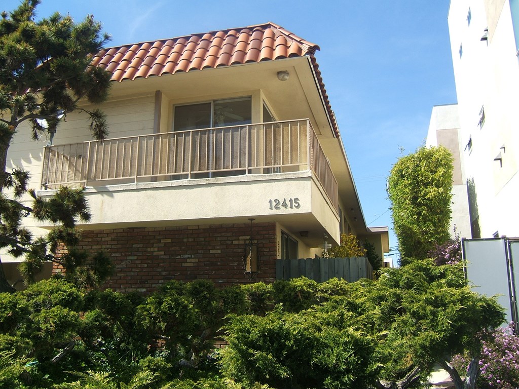 an apartment building with a balcony and a brick wall