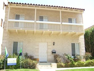 a white house with a balcony and a white door