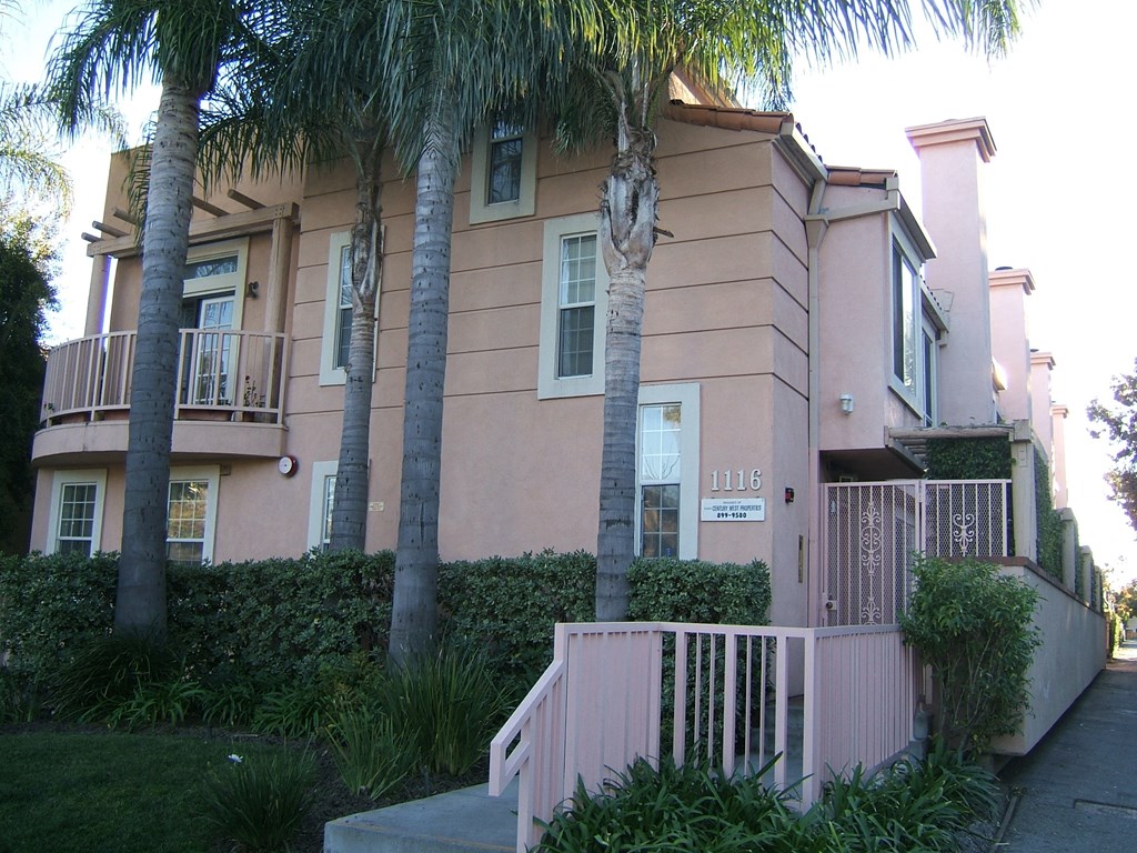 a pink house with palm trees in front of it