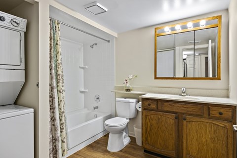 A bathroom with a toilet, sink, and mirror.