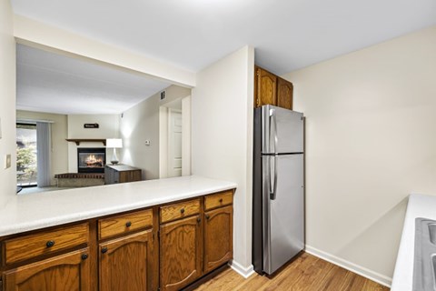 A kitchen with wooden cabinets and a stainless steel refrigerator.
