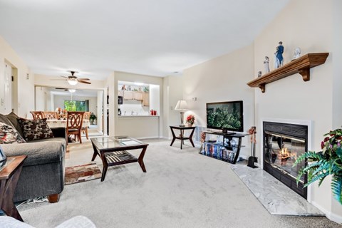A living room with a fireplace and a painting on the wall.