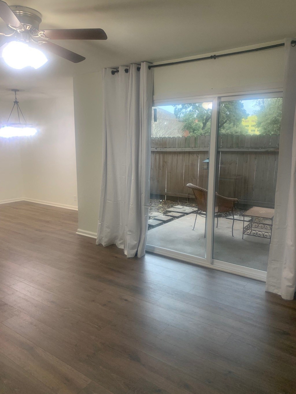 an empty living room with sliding glass doors to a patio
