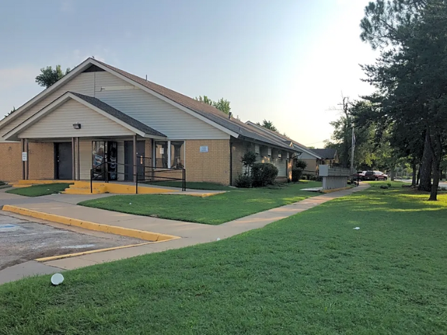 a building with a yard and a sidewalk in front of it