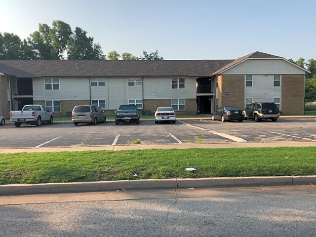 a parking lot with cars in front of a building