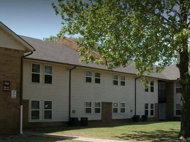 a white building with a tree in front of it