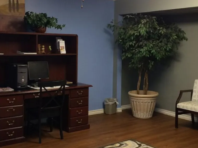 an office with a desk and a potted plant