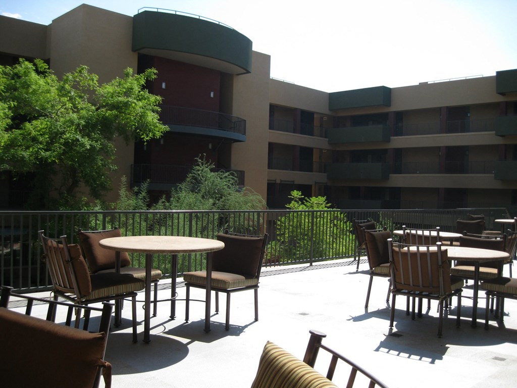 an outside patio area of a hotel with tables and chairs