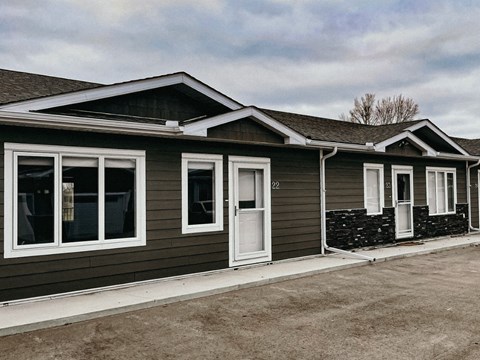 A row of houses with grey siding and white trim.