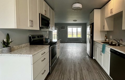 A kitchen with white cabinets and black appliances.
