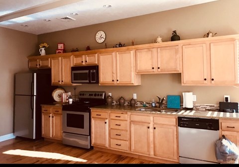 a kitchen with wooden cabinets and stainless steel appliances