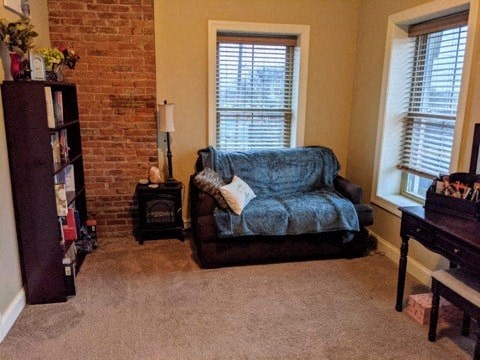 a living room with a couch and a brick wall