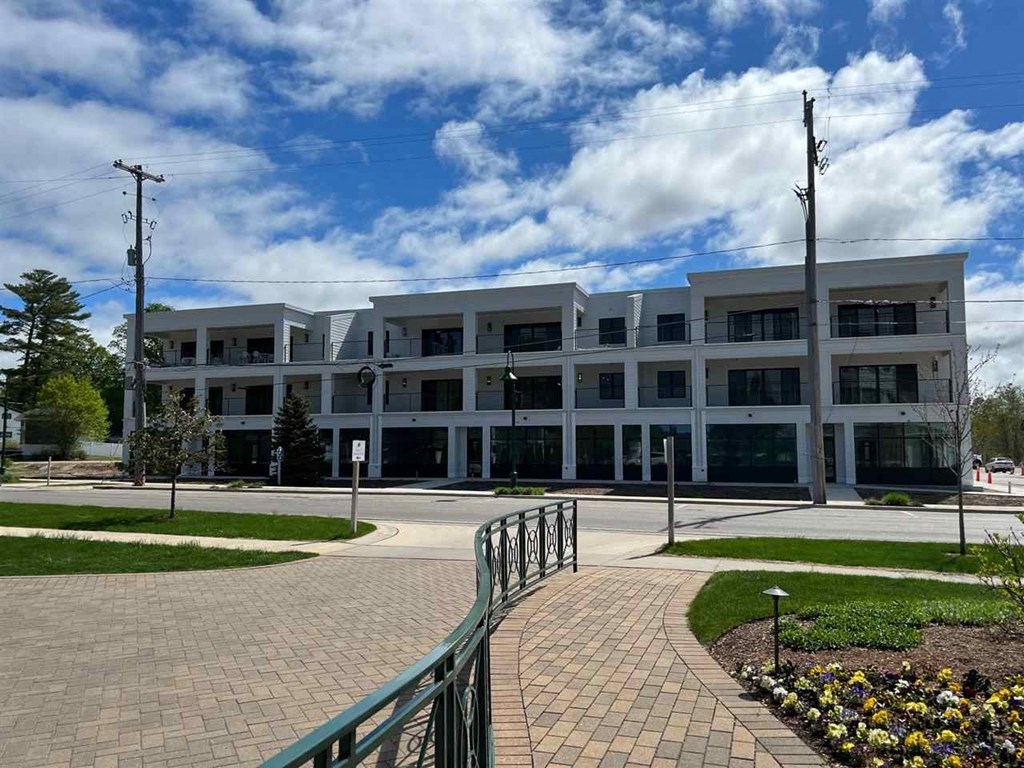 a large white building with a sidewalk in front of it