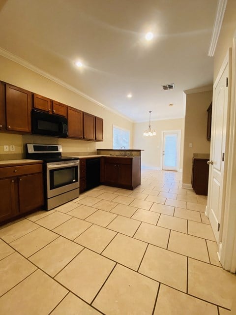 a large kitchen with tiled flooring and wooden cabinets