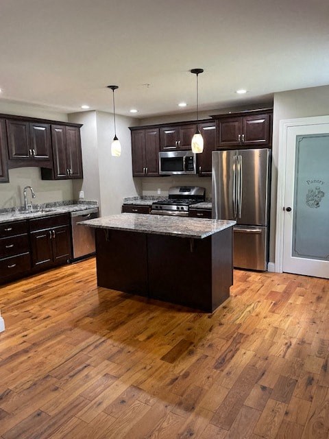 a kitchen with stainless steel appliances and wooden floors