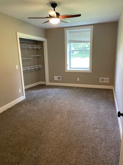 an empty room with a ceiling fan and a window