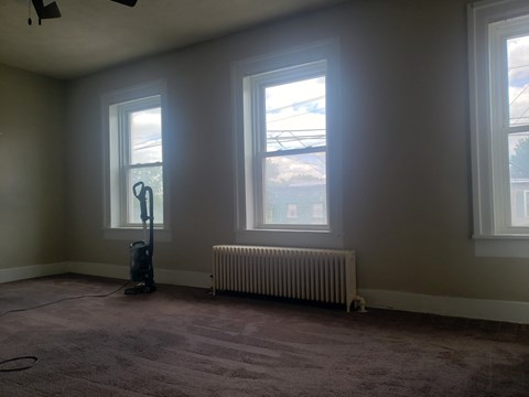 A room with a vacuum cleaner and a radiator.