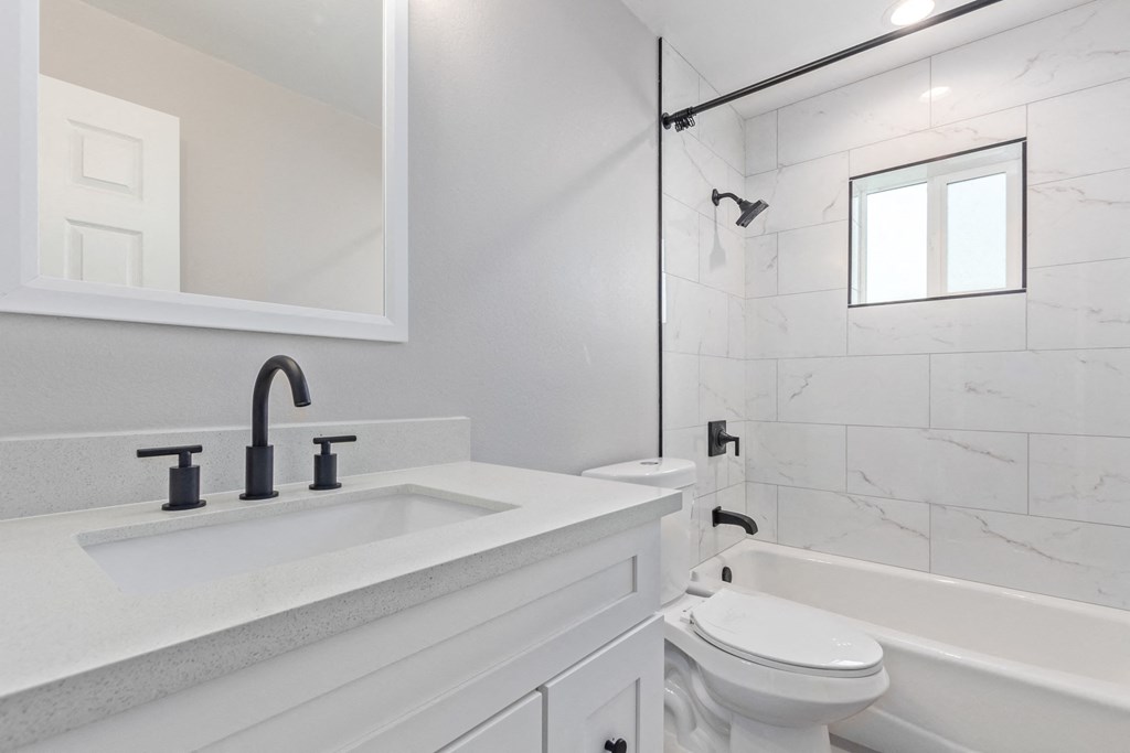 a white bathroom with a sink and a toilet
