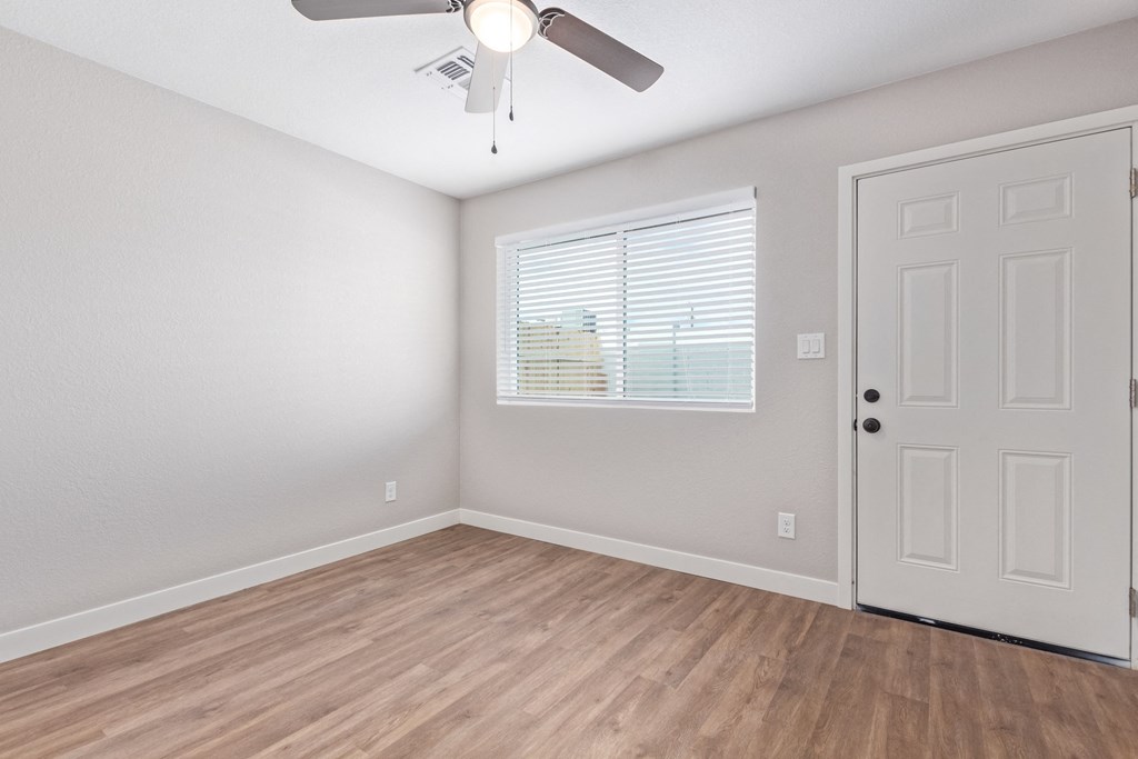 an empty room with a ceiling fan and a window