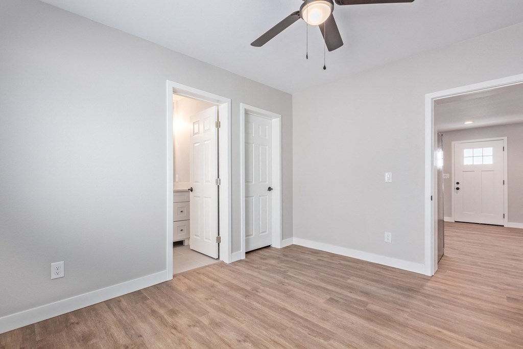 an empty living room with a ceiling fan