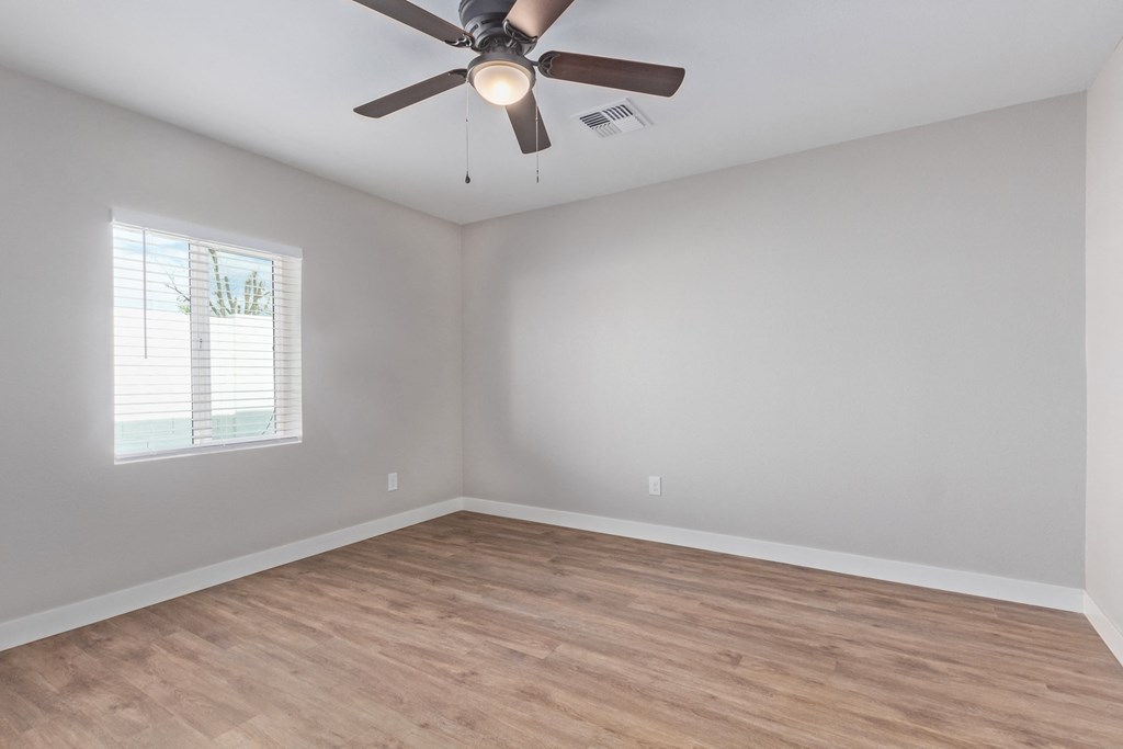 an empty room with a ceiling fan and a window