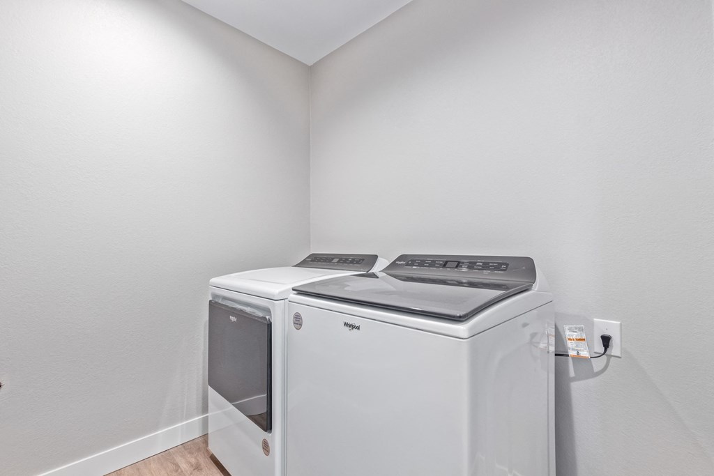 a washer and dryer in the corner of a room with a white wall