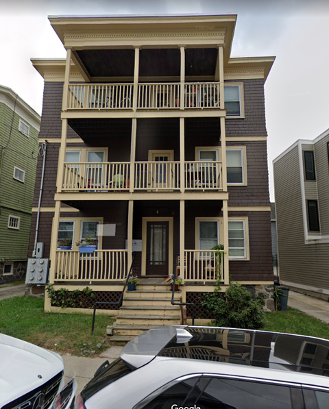 A two-story apartment building with a balcony on the second floor.
