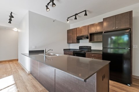 A modern kitchen with a black refrigerator and stove.