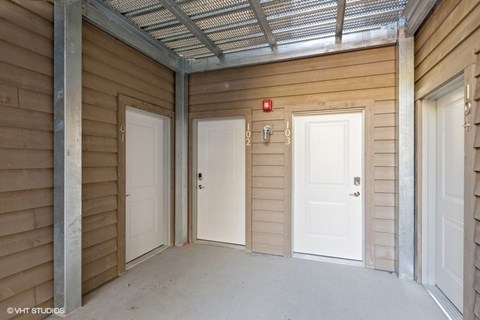 A room with three doors and a fire extinguisher on the wall.