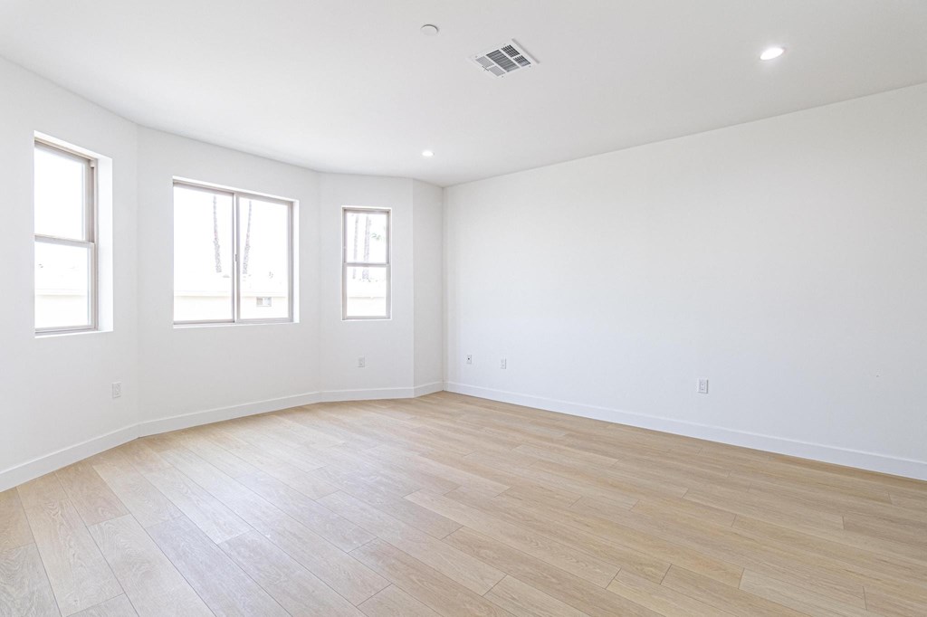 an empty living room with white walls and wood floors