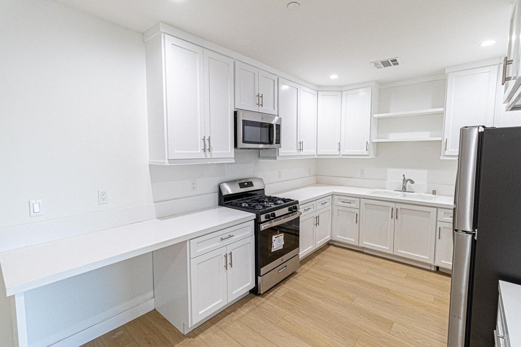 a kitchen with white cabinets and a stove and a refrigerator