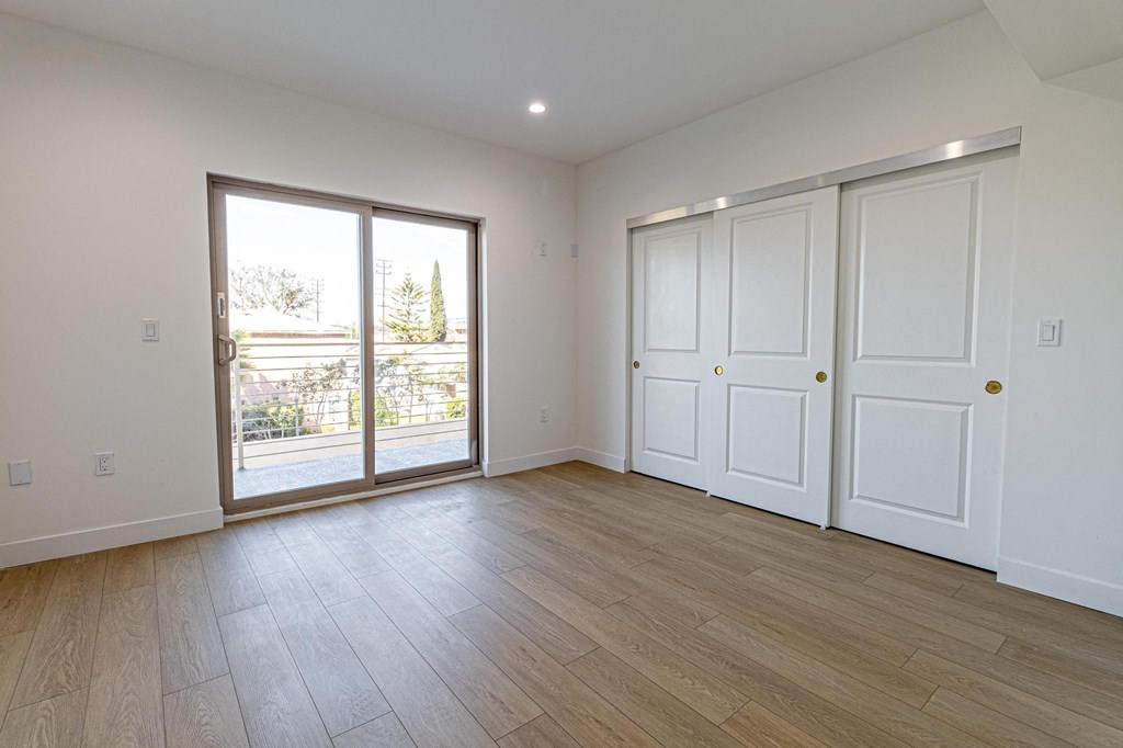 an empty living room with white walls and a sliding glass door