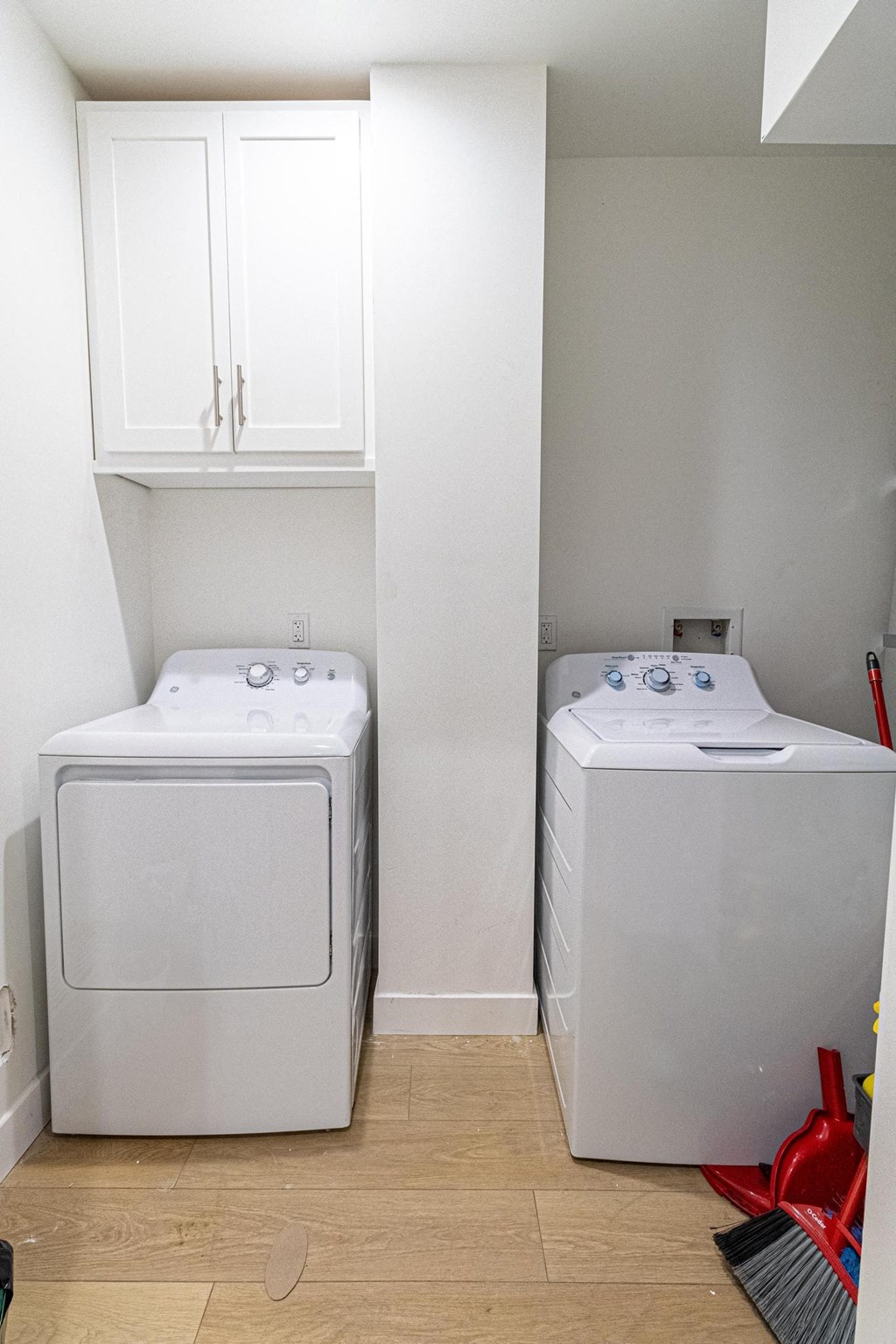 a washer and dryer in a laundry room with white cabinets