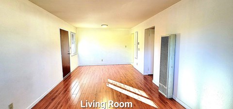 an empty living room with white walls and wood floors
