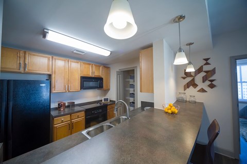 a kitchen with a large island and a black refrigerator