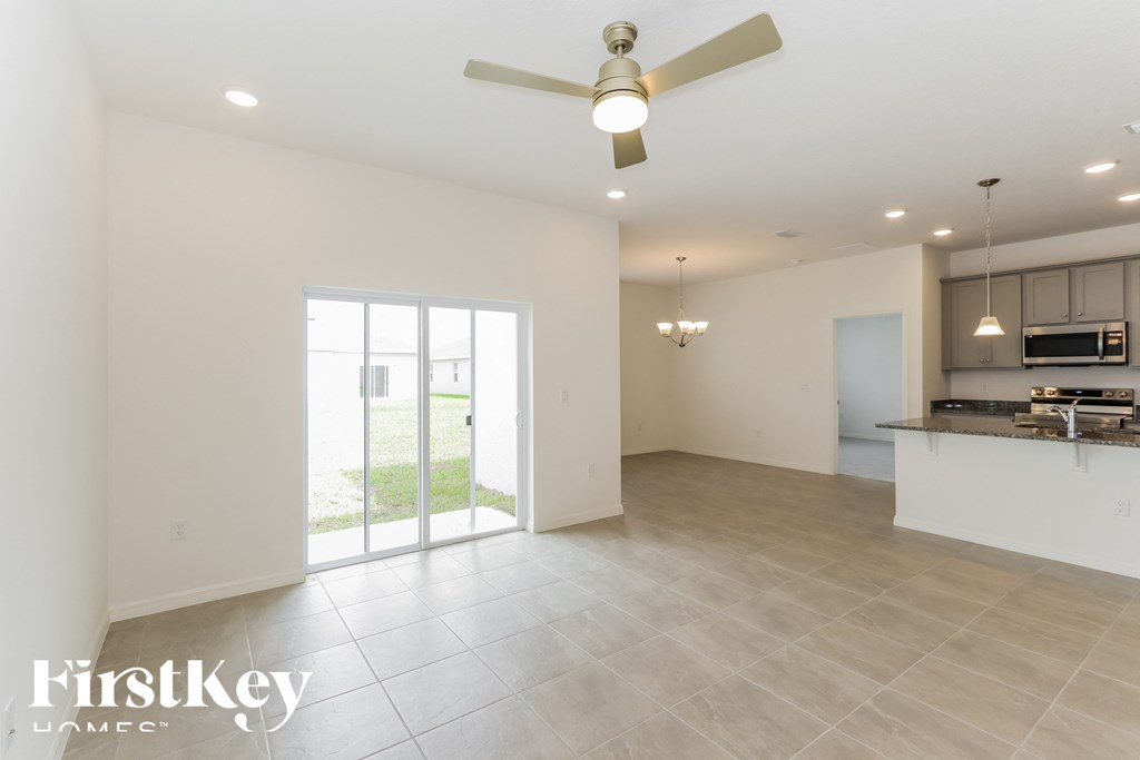a kitchen and living room with a ceiling fan