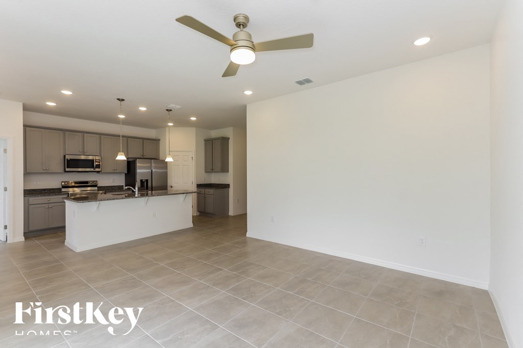 an open kitchen and living room with a ceiling fan