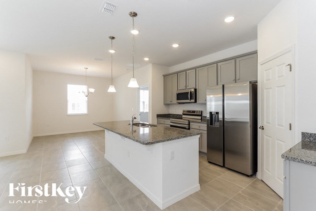 a large kitchen with stainless steel appliances and granite counter tops