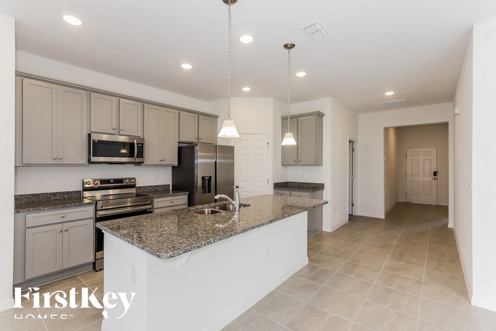a large kitchen with granite counter tops and stainless steel appliances