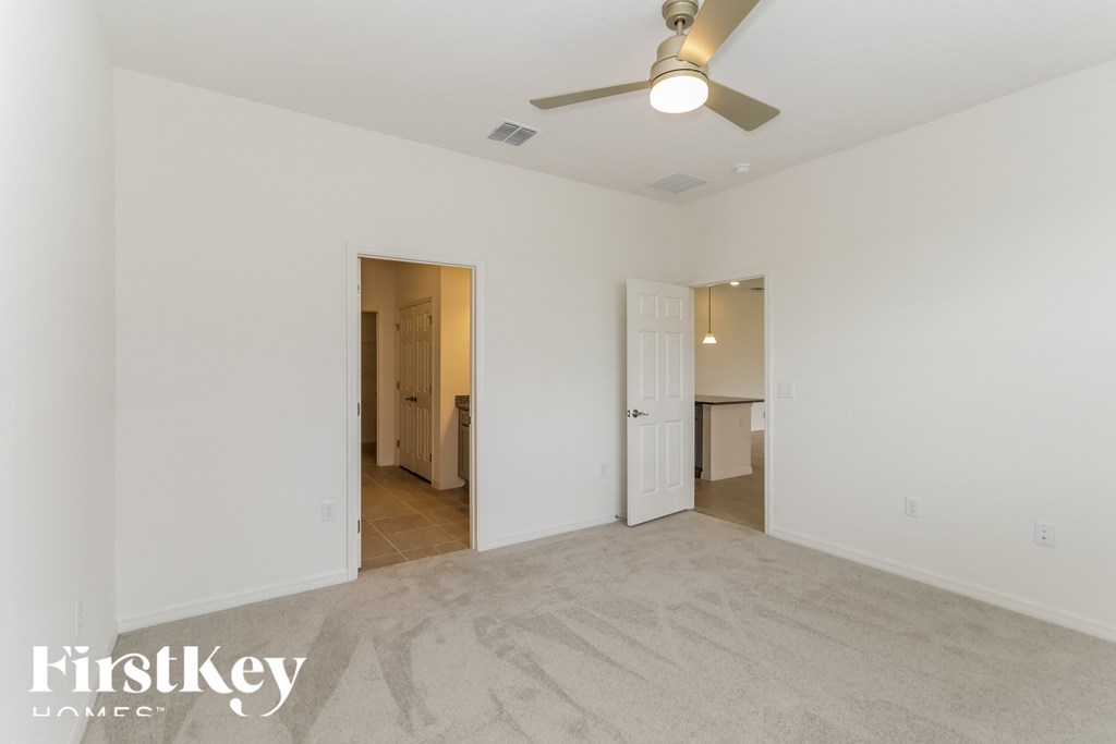 a living room with white walls and a ceiling fan
