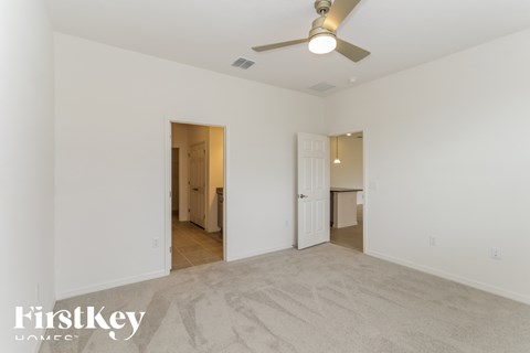 a living room with white walls and a ceiling fan