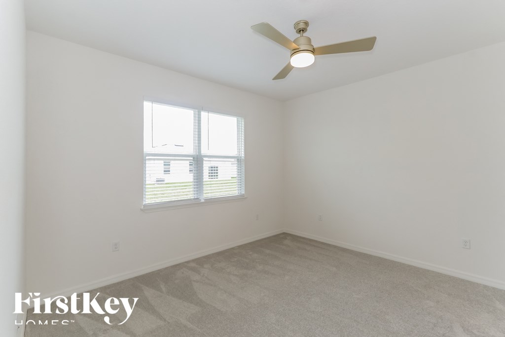 a bedroom with a ceiling fan and a window