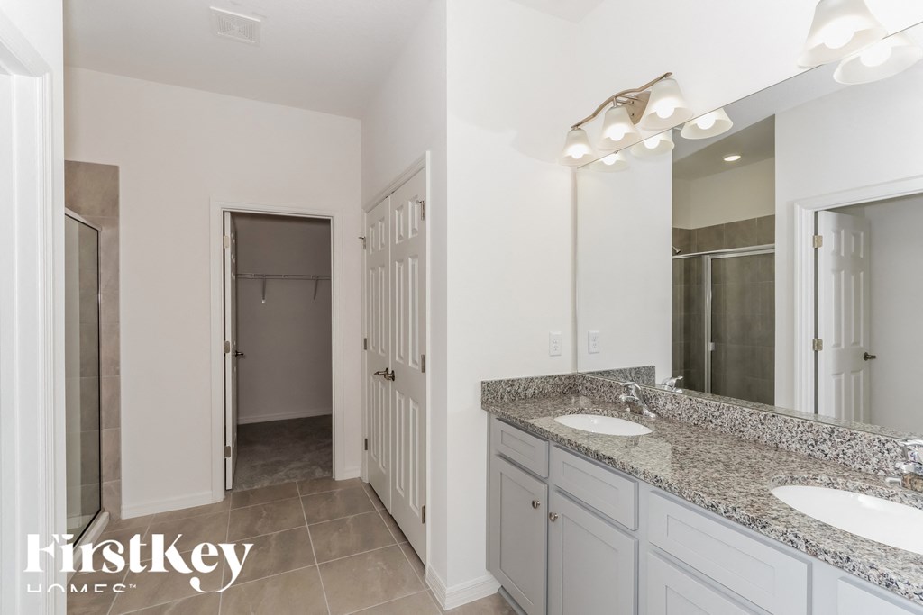 a bathroom with two sinks and a mirror and a shower