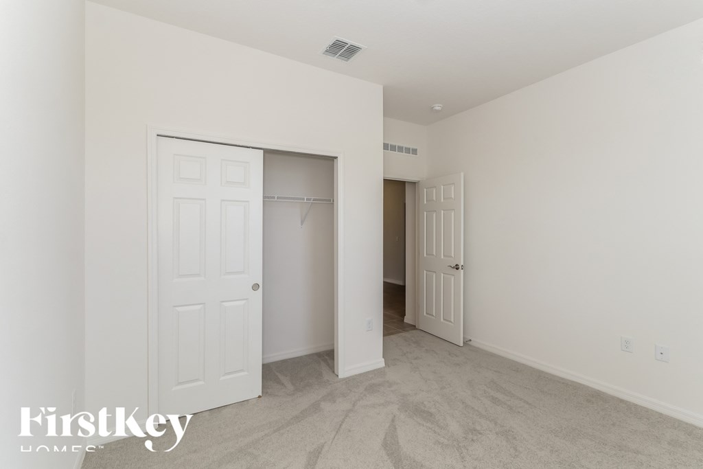 a master bedroom with a closet and a door to a hallway