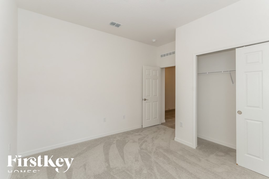 a master bedroom with a closet and a door to a walk in closet