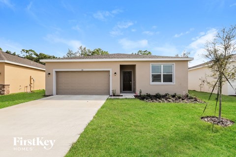 a beige house with a driveway and a garage door