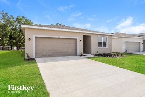 a beige house with a driveway and a garage door