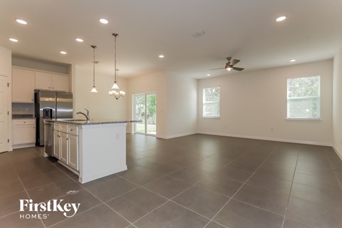 an open kitchen and living room with a large island and stainless steel appliances