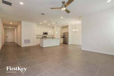 an open kitchen and living room with a ceiling fan