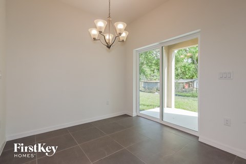 a dining room with a sliding glass door to the backyard